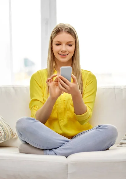 Jong vrouw of tiener meisje met smartphone thuis — Stockfoto