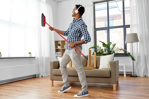 Hombre con escoba limpieza y divertirse en casa — Foto de Stock