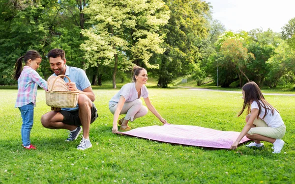 Familie leggen picknickdeken in zomerpark — Stockfoto