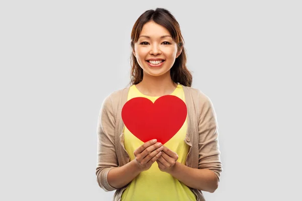Kırmızı kalpli mutlu Asyalı kadın. — Stok fotoğraf