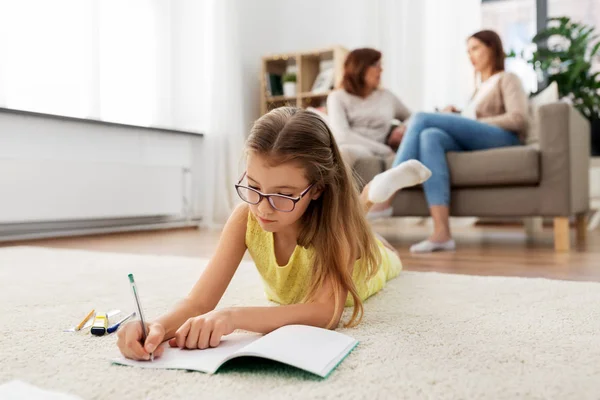 Estudante menina escrevendo para notebook em casa — Fotografia de Stock