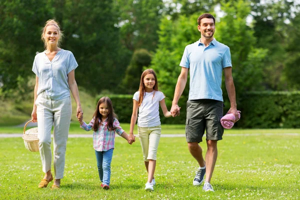 Οικογένεια με καλάθι πικ-νικ περπάτημα στο πάρκο το καλοκαίρι — Φωτογραφία Αρχείου