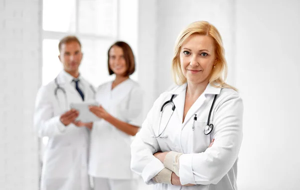 Smiling doctor in white coat at hospital Stock Picture