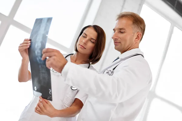 Doctors with x-ray of spine at hospital — Stock Photo, Image