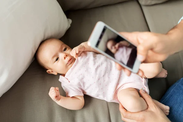 Apja okostelefonnal vesz képet Baby otthon — Stock Fotó