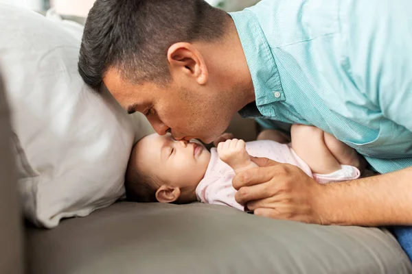 Отец среднего возраста целует маленькую дочь дома — стоковое фото
