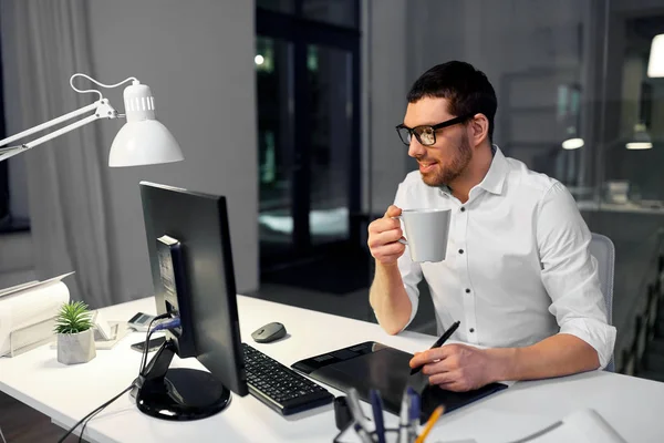 Designer with pen tablet drinking coffee at office — Stock Photo, Image