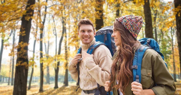 Pareja sonriente con mochilas senderismo en otoño — Foto de Stock