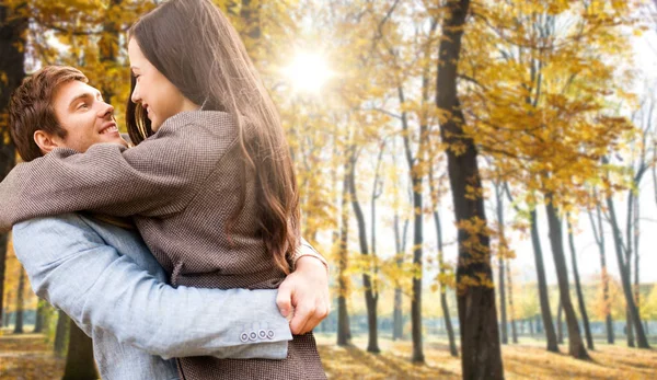 Uśmiechnięta para przytulająca się w jesiennym parku — Zdjęcie stockowe