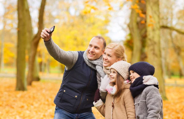 Familia feliz con la cámara en el parque de otoño —  Fotos de Stock