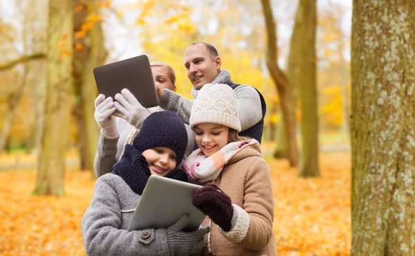 Šťastná rodina s tablet pc v podzimním parku — Stock fotografie