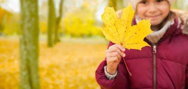 Primer plano de niña con hoja de arce en otoño —  Fotos de Stock