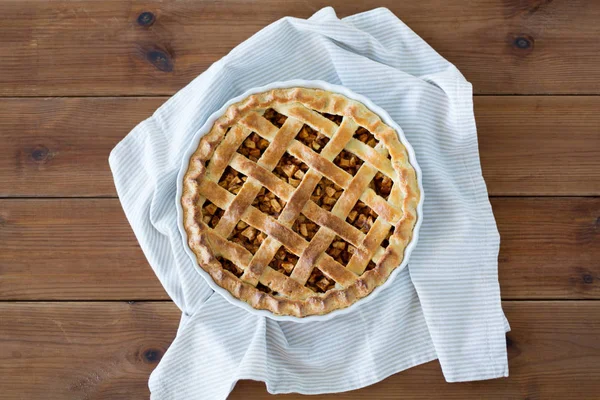 Close up of apple pie in mold on wooden table — Stock Photo, Image