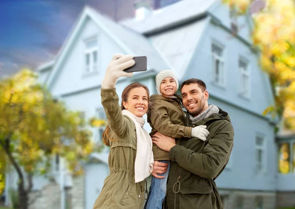 Сім'я бере селфі через будинок смартфона восени — стокове фото