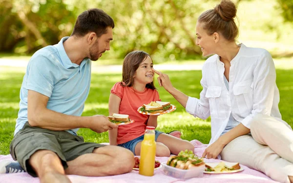 Familia feliz teniendo un picnic en el parque de verano — Foto de Stock