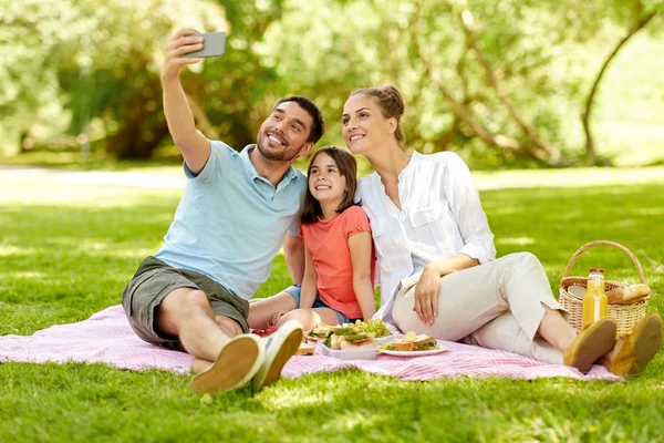 Сім'я має пікнік і приймає селфі в парку — стокове фото
