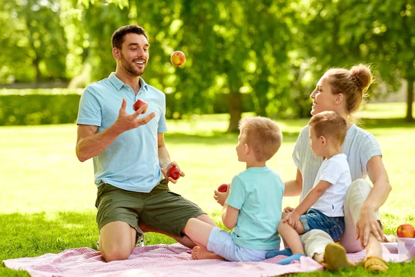 Família feliz fazendo piquenique no parque de verão — Fotografia de Stock