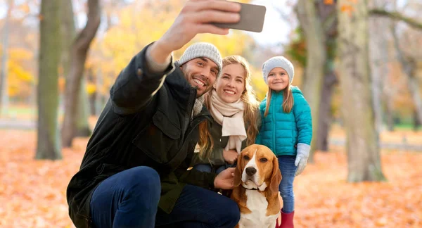 Lycklig familj med hund tar selfie i höstparken — Stockfoto