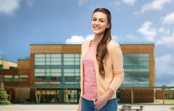 Usmívající se mladá studentka přes školní pozadí — Stock fotografie