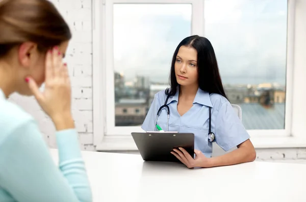 Médecin avec presse-papiers et patient à la clinique — Photo