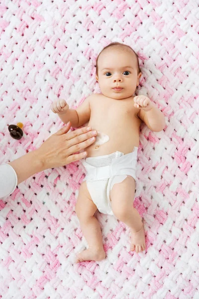 Χέρι εφαρμογή λοσιόν σώματος για το μωρό κορίτσια κοιλιά — Φωτογραφία Αρχείου