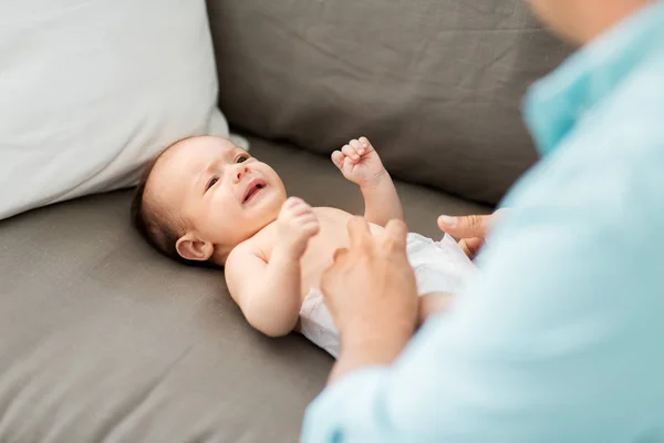 W średnim wieku ojciec zmienia Babys pieluchy w domu — Zdjęcie stockowe