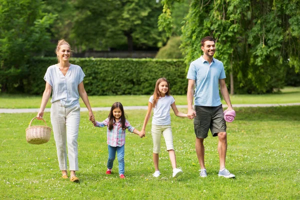 Οικογένεια με καλάθι πικ-νικ περπάτημα στο πάρκο το καλοκαίρι — Φωτογραφία Αρχείου