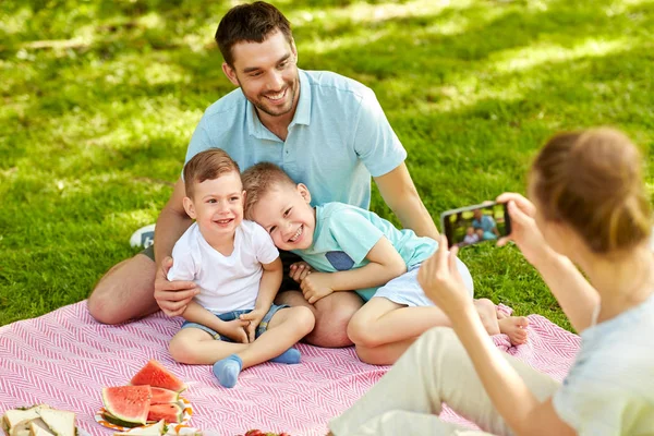 Mutter fotografiert Familie bei Picknick im Park — Stockfoto