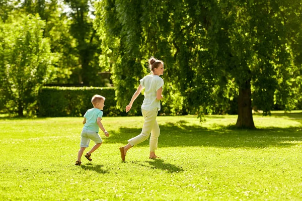 Anya és fia játszani catch game a nyári parkban — Stock Fotó
