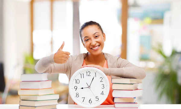 African american student with clock and books — Stock Photo, Image