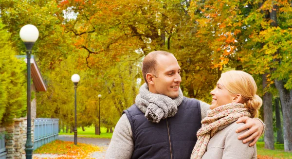 Usmívající se pár v podzimním parku — Stock fotografie