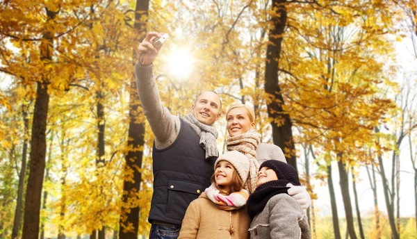 Happy family with camera in autumn park — Stock Photo, Image