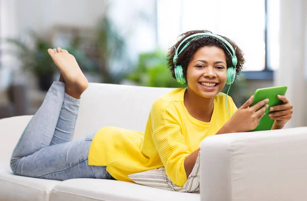 Gelukkig Afrikaanse vrouw met tablet pc en hoofdtelefoon — Stockfoto