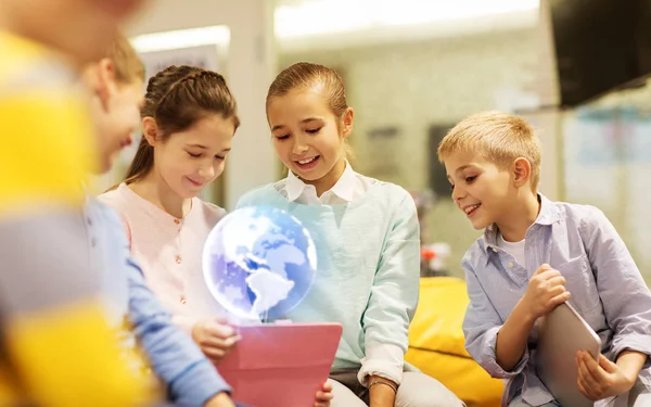 Niños con la tableta PC y holograma del planeta de la tierra —  Fotos de Stock