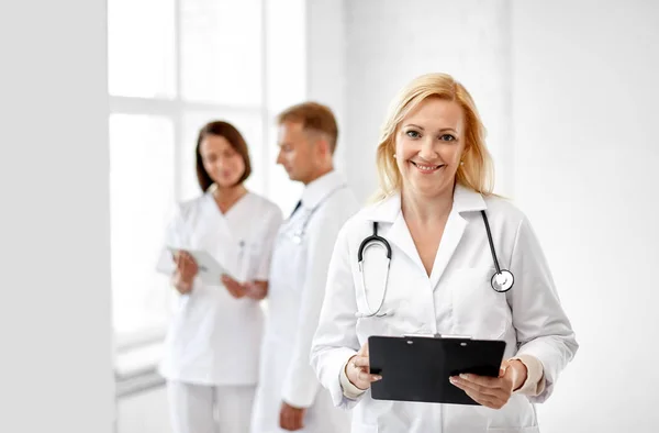 Smiling doctor with clipboard and stethoscope — Stock Photo, Image