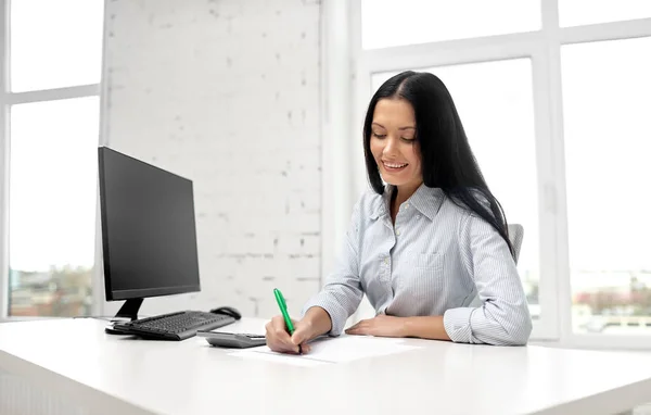 Bizneswoman pisząc do notebooka w biurze — Zdjęcie stockowe
