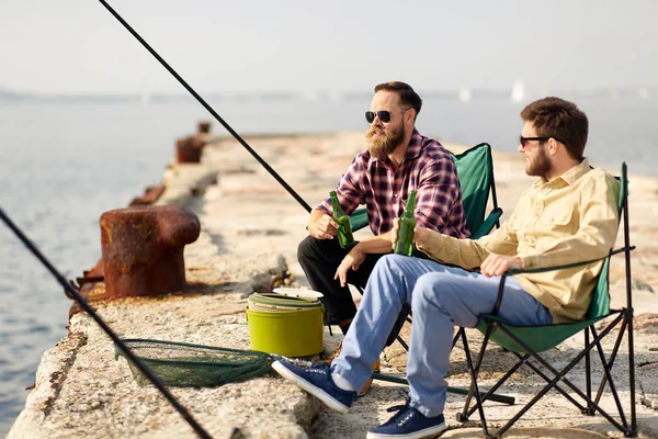 Amici felici pesca e bere birra sul molo — Foto Stock