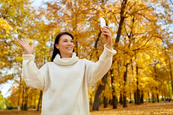 秋天公园里拿着智能手机自拍的女人 — 图库照片