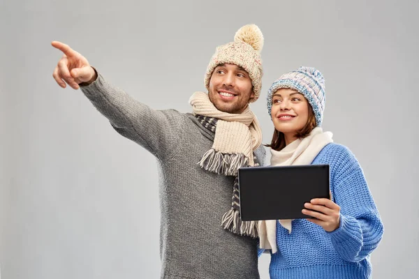 Пара в зимней одежде с планшетным компьютером — стоковое фото