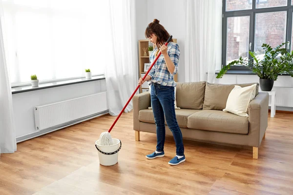 Femme ou femme au foyer avec sol nettoyant à la maison — Photo