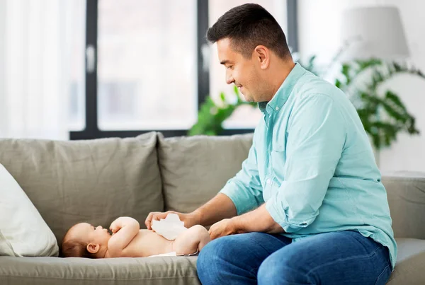 Middelbare leeftijd vader veranderende babys luier thuis — Stockfoto