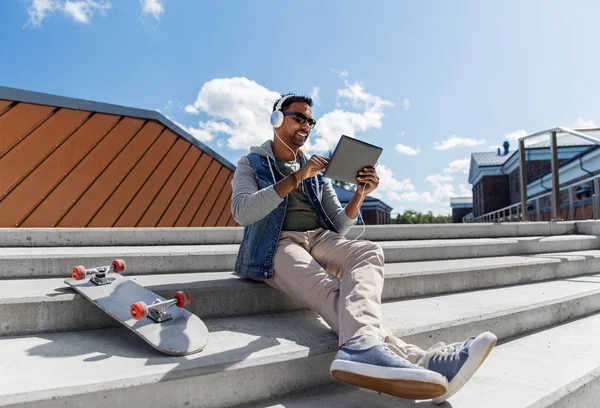 Man met Tablet PC en koptelefoon op dak — Stockfoto