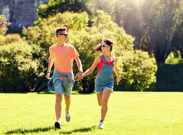 Счастливая пара подростков, бегающих в летнем парке — стоковое фото