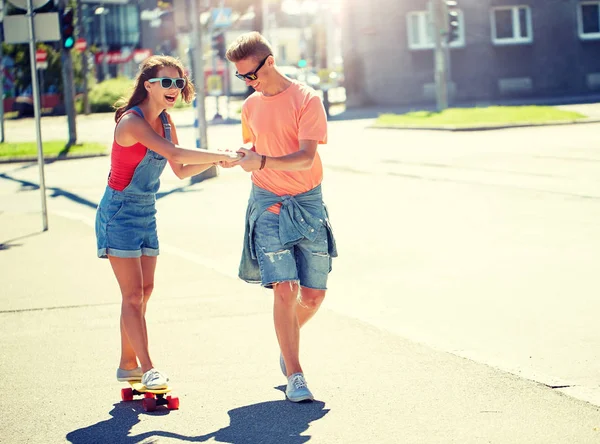 Pareja adolescente montando monopatines en la calle de la ciudad — Foto de Stock