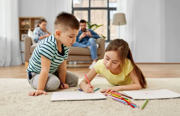 Hermano y hermana dibujando con crayones en casa — Foto de Stock
