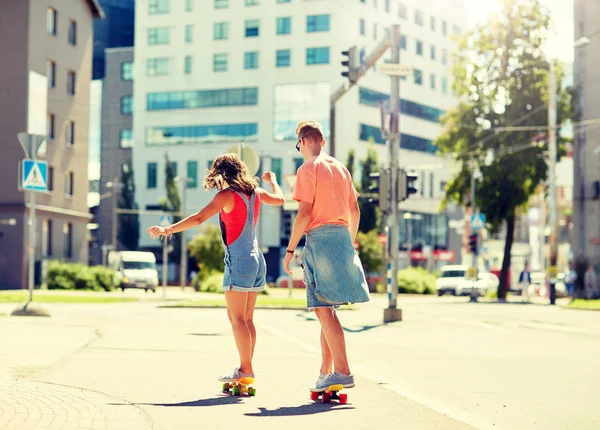 Tiener paar paardrijden skateboards op stad straat — Stockfoto