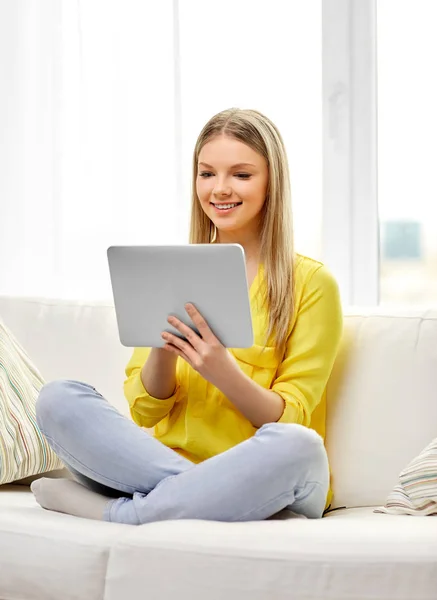 Jong vrouw of tiener meisje met tablet pc thuis — Stockfoto