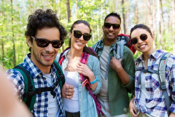 Vrienden met rugzakken wandelen en selfie — Stockfoto