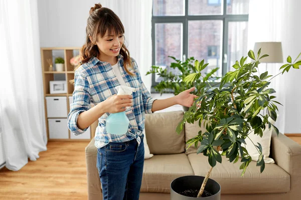 Boldog ázsiai nő permetezés szobanövények otthon — Stock Fotó