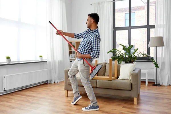 Hombre con escoba limpieza y divertirse en casa — Foto de Stock